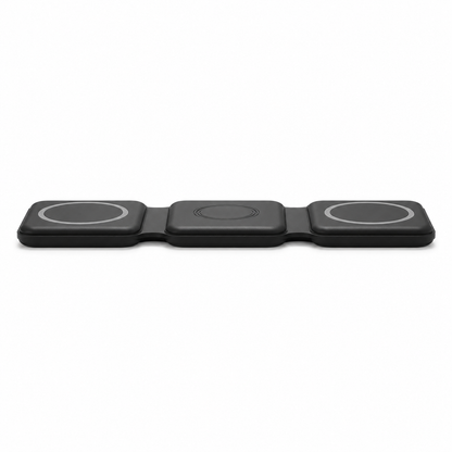 Extreme low-angle side profile view of the PrimeSync black foldable magnetic travel charger lying flat on a desk. Highlights the exceptionally slim, low-profile design and the flexible silicone hinges engineered for compact travel storage.