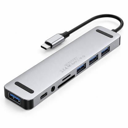 Underside view of the PrimeSync USB-C Hub, showing two non-slip black rubber grip pads on the silver aluminum bottom plate. Laser-etched text displays standard global consumer electronic regulatory compliance marks including CE, FCC, and RoHS certifications.