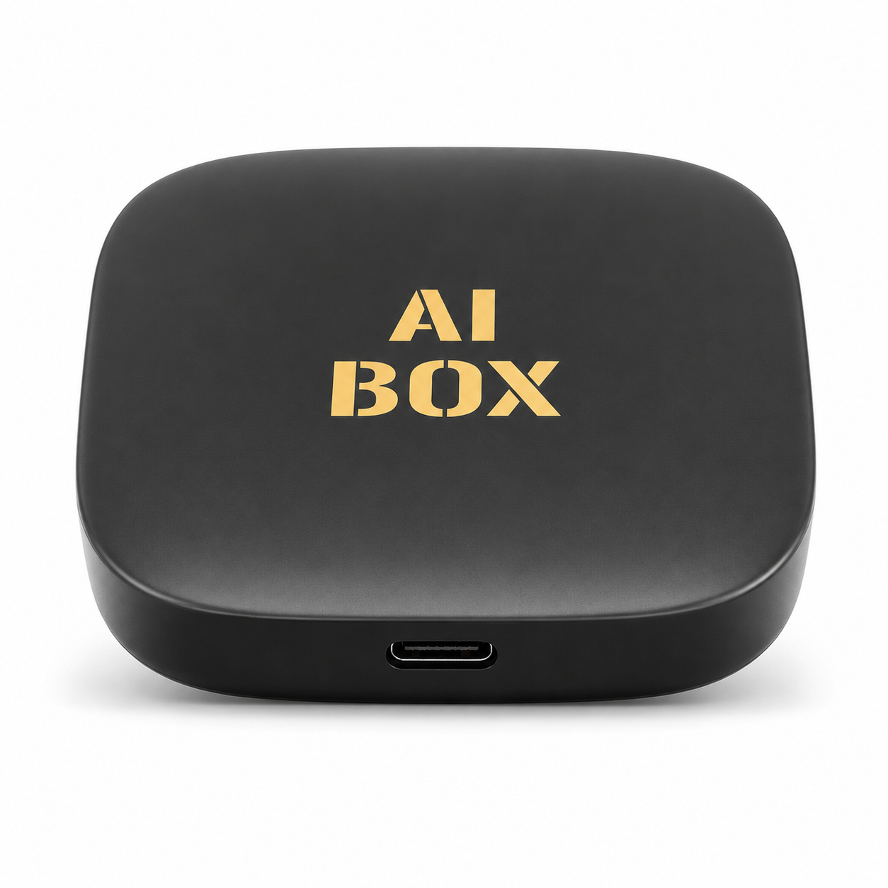 Top-down view of the PrimeSync Wireless CarPlay AI Box. Features a compact, rounded square-shaped matte black casing with a gold 'AI BOX' logo printed in the center and a modern USB-C connection port on the front edge.